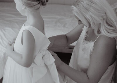 Bride helping flower girl get ready at Tournerbury Woods wedding in Hampshire